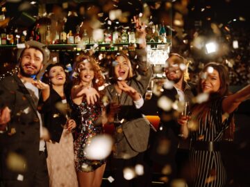 Happy friends throwing confetti and jumping while enjoying party Confetti is fun. Party, celebration