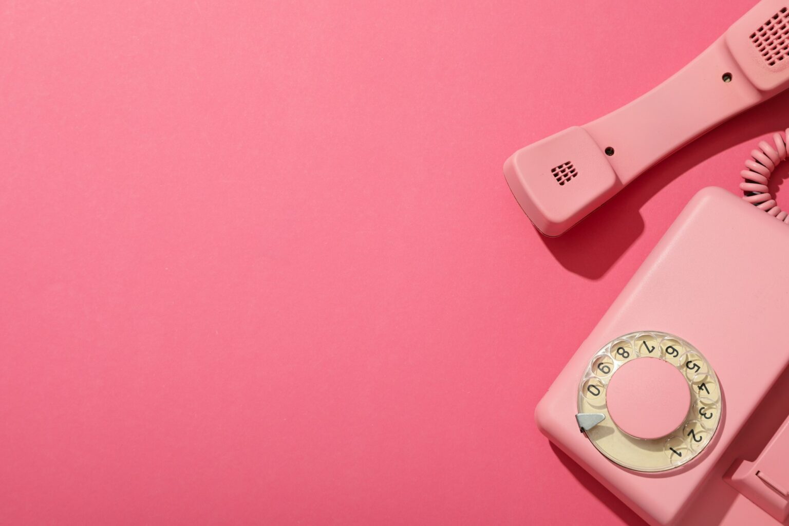 Le téléphone rose, encore d’actualité ? Landline phone on pink background, space for text