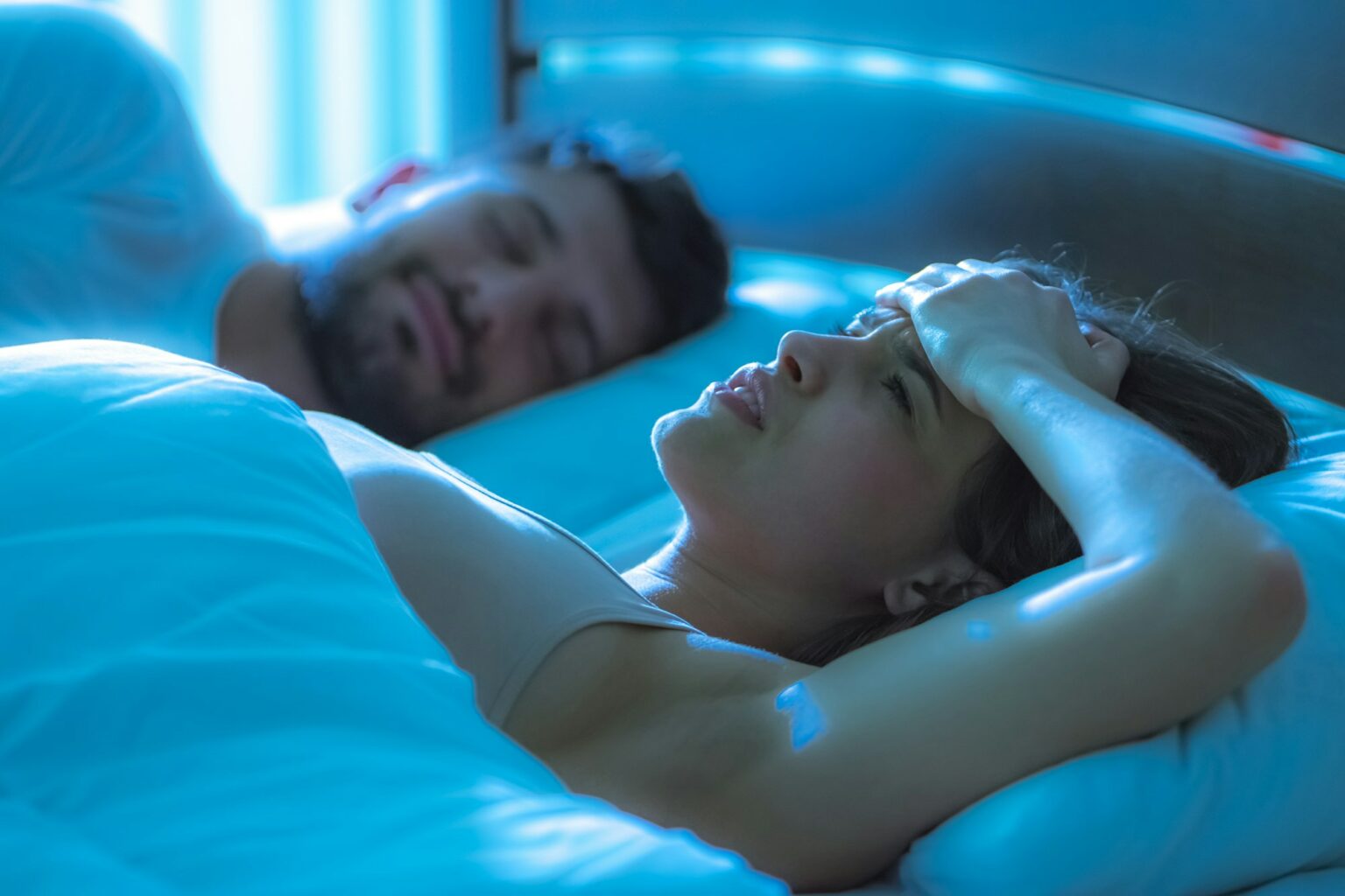 The illness woman lay near a man in the bed. night time