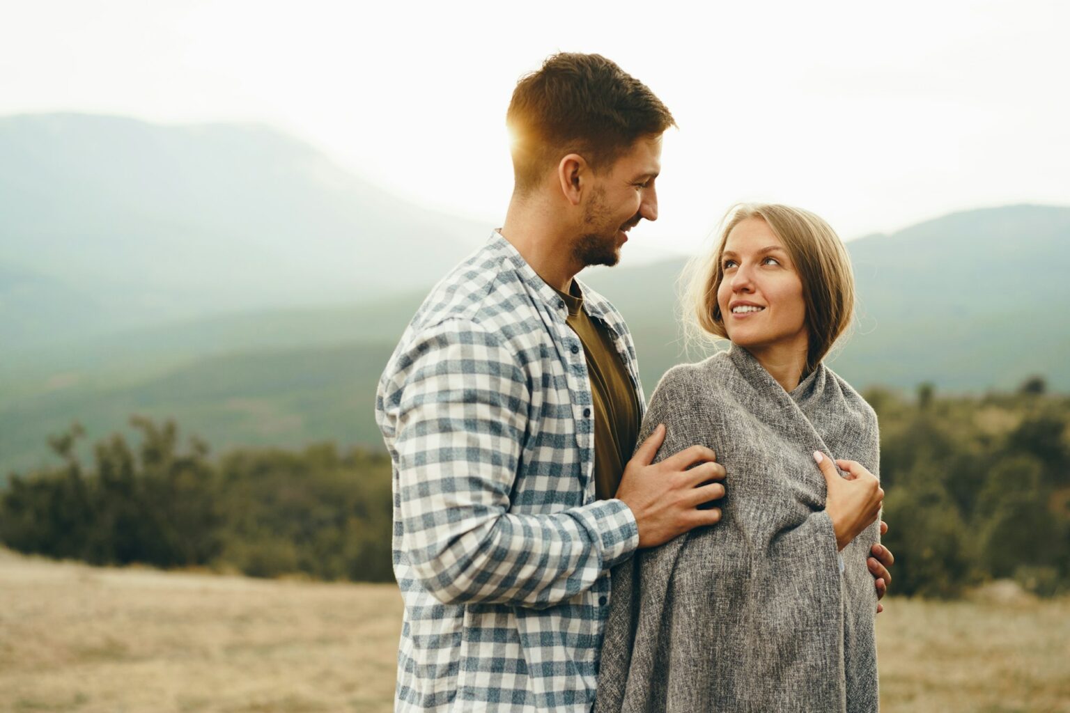 Les 5 langages de l’amour : la clé pour faire durer son couple Happy loving couple hiking and hugging in mountains