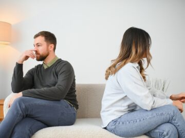 Man and woman feeling stressed and angry at each other, frustrated couple sitting back to back