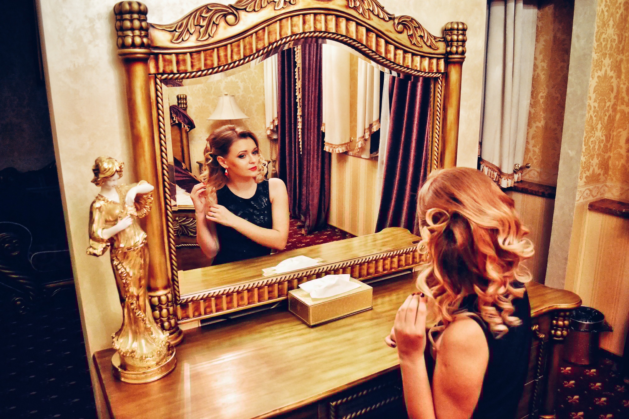 Beautiful luxury woman looking in a golden mirror