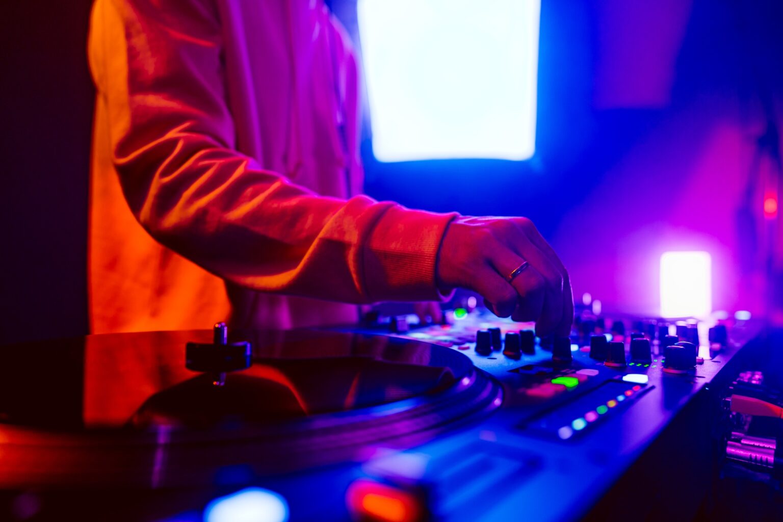 Les 100 meilleurs DJ du monde (toutes générations) Hands of a DJ creating and regulating music on dj console mixer at club concert