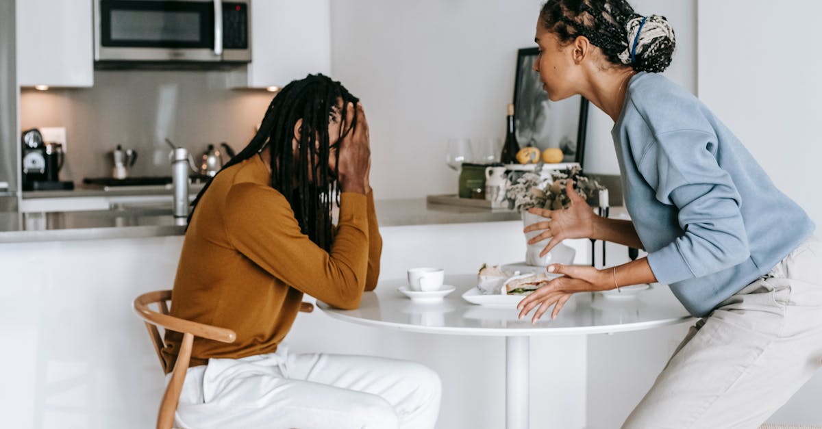 un couple malheureux signe des documents, reflétant des tensions et des conflits dans leur relation.